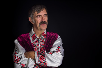 Indoor portrait of mature Ukrainian country-man in traditional clothes