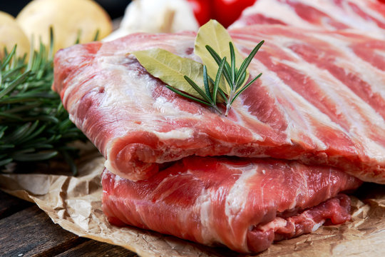Raw ribs with a rosemary and vegetables. on crumpled paper