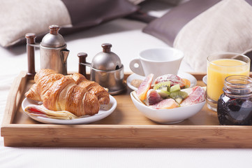 Tray with breakfast on a bed in a hotel room