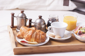 Fototapeta na wymiar Tray with breakfast on a bed in a hotel room