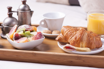 Tray with breakfast on a bed in a hotel room