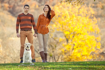 Fototapeta premium Two lovely people are walking on the nature with labrador