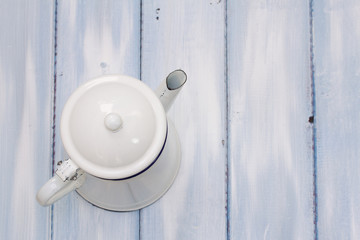 white coffee pot on blue wooden background