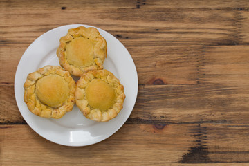 cake with chicken on white plate on brown wooden background