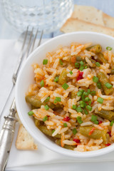 rice with vegetables in white bowl and glass of water