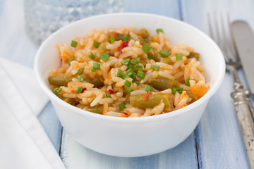 rice with vegetables in white bowl and glass of water