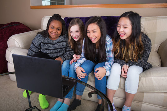 Small group of young girl friends watching streaming tv on compu