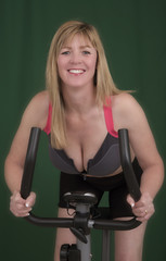 Fototapeta na wymiar Portrait of a woman riding an exercise bike