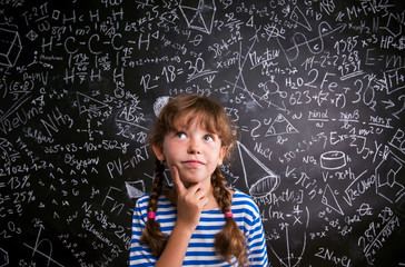 Girl  thinking, finger on cheek, blackboard with mathematical sy