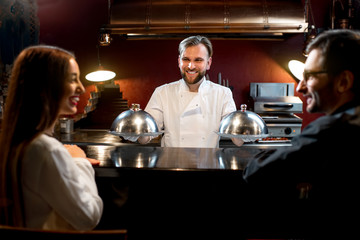 Chef cook serving dishes to the couple
