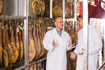 Technologist with butcher checking  wurst