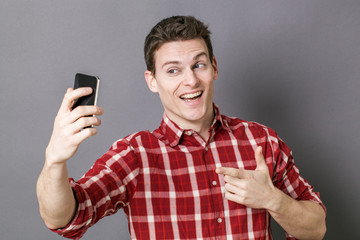 male selfie - cheesy young sportsman taking selfie for seduction over gray background studio...