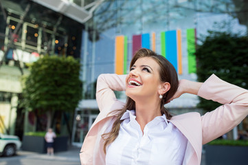 Fototapeta premium Smiling businesswoman with hands on head against modern building