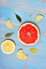 Citrus fruits slices over blue wooden table. Top view. Selective focus