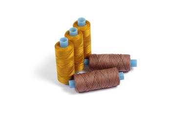 Five sewing spools on white backgrouns - brown and orange