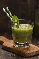 Glass of green refreshing smoothie with kiwi, cucumber and apple. Toned image. Selective focus
