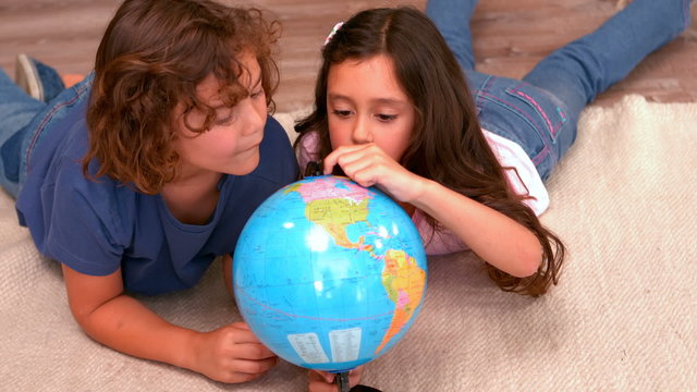 Brother and sister holding a globe