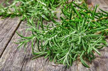 Bunch of fresh rosemary herbs on rustic wooden table