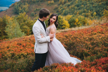 happy newly married couple posing in the mountains