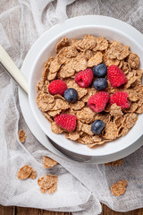 Bowl of cereals with blueberries and raspberrie.