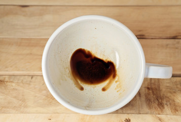 Coffee cup / Coffee cup with coffee stains have not washed the cup placed on the wooden floor. Top view.