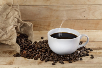 Hot coffee / Hot coffee and coffee beans placed on a wooden floor.