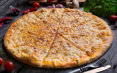 Hot cheese pizza on old wooden table