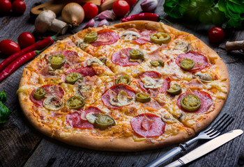 Pepperoni pizza with ham and jalapeno chili peppers