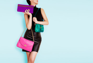 Woman holding many colorful bags. Isolated on light blue. Shopping. Fashion image. 