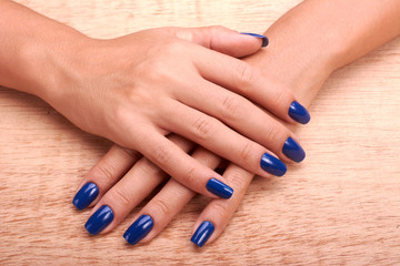 Obraz na płótnie Canvas Woman hands with blue manicure and nail polish