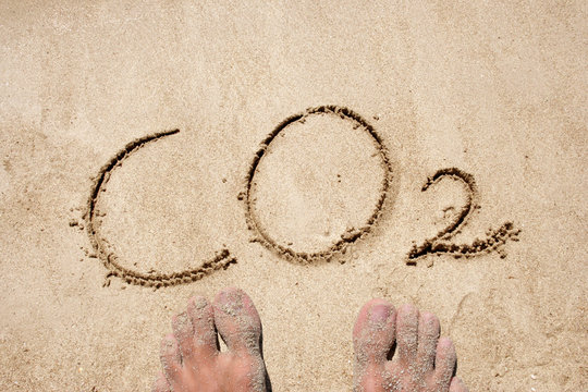 Conceptual CO2 text handwritten in sand on a beach in an exotic island