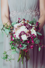 Fototapeta na wymiar Wedding bouquet of flowers, young bride holding a bouquet of flowers. Image of wedding dress and floral bouquet.