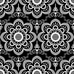 Background pattern with white mehndi seamless lace decoration items on black background.