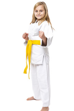 Portrait of a karate girl in kimono with yellow belt ready to fi