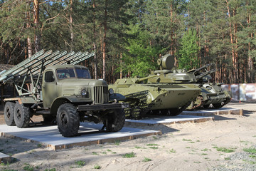 February 23 is celebrated in the Russian Federation as the day of all men. Military vehicles parked at a military base in the pine forest.