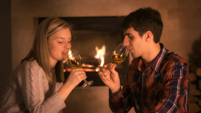 Couple sitting at home by the fireplace.
