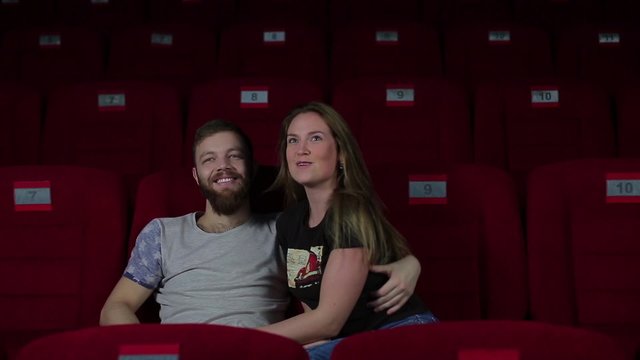 Boy and girl making fun in the cinema.