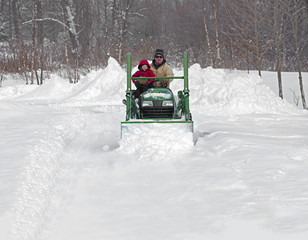 Father and son plowing snow