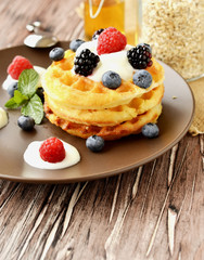 Belgian waffles with berries and honey selective focus