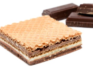 Wafer with hazelnut and milk cream with pieces of dark chocolate on white background.