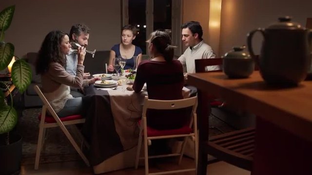 Group of young people dinning together. The camera moves. 4K, UHD