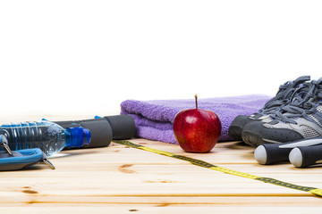 Dumbbells, Jump Rope, Towel, Sport Shoes, Ankle Weights, Tape Measure, Apple And Bottle Of Water On Wooden Floor. Sport Fitness Background.