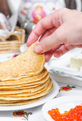 Hand takes a pancake from the stack