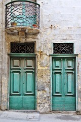 Fototapeta na wymiar Green door on an old stone building in Malta