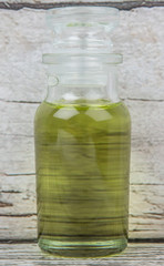 Grape seed oil in glass vial over wooden background