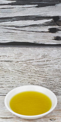 Avocado oil in white bowl over wooden background