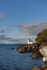 Fototapeta na wymiar Line Kiln Lighthouse. Located on San Juan Island, in Washington state, It guides ships through the Haro Straits and is part of Lime Kiln Point State Park. It overlooks Dead Mans Bay.