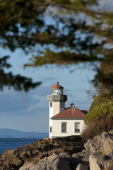 Fototapeta na wymiar Line Kiln Lighthouse. Located on San Juan Island, in Washington state, It guides ships through the Haro Straits and is part of Lime Kiln Point State Park. It overlooks Dead Mans Bay.