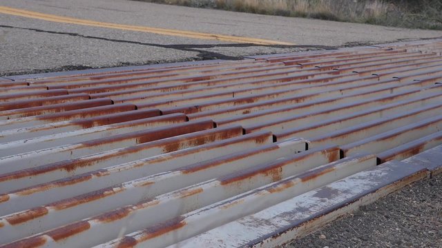 A truck crossing a cattle guard out west