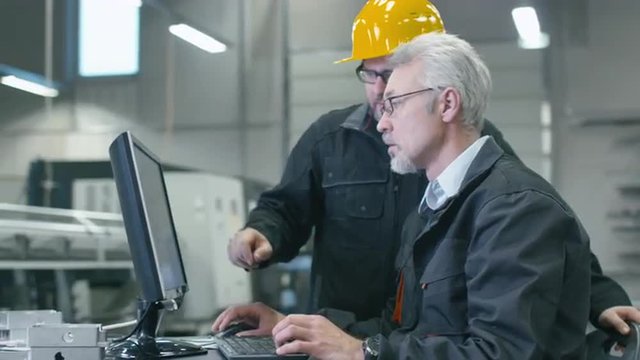 Two engineers are working on a desktop computer in a factory. Shot on RED Cinema Camera.